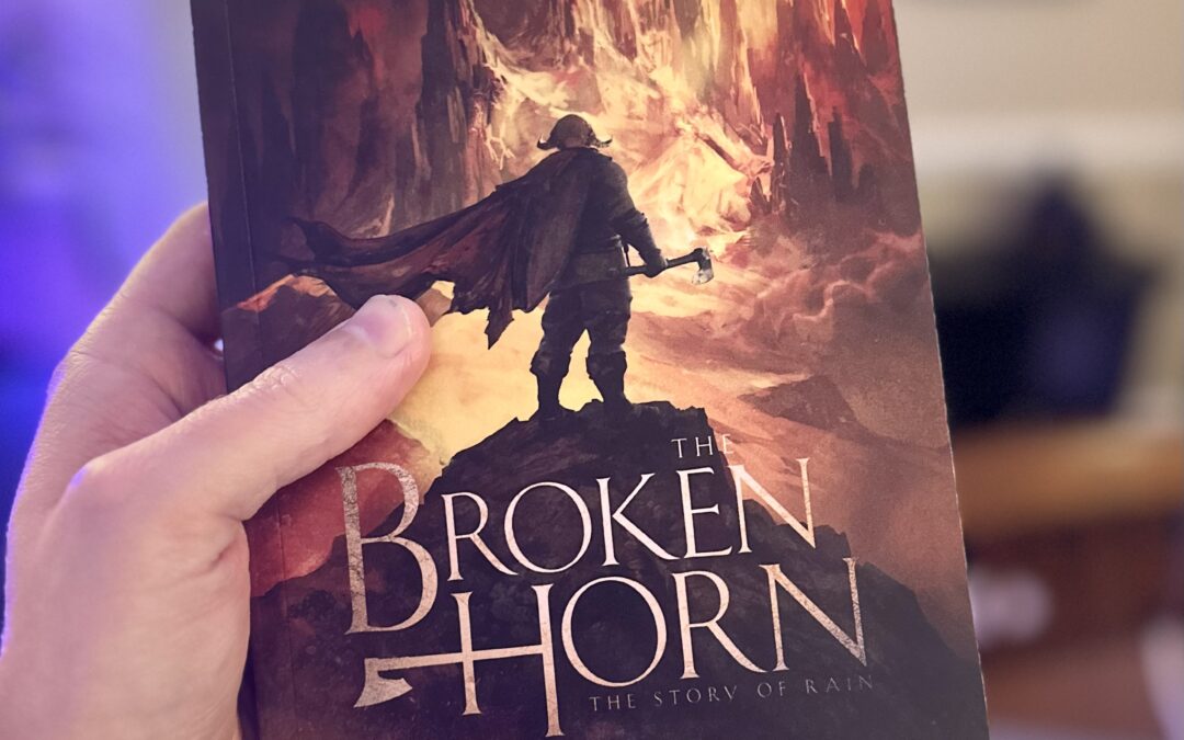 Don Elliott holding up a paperback copy of The Broken Horn